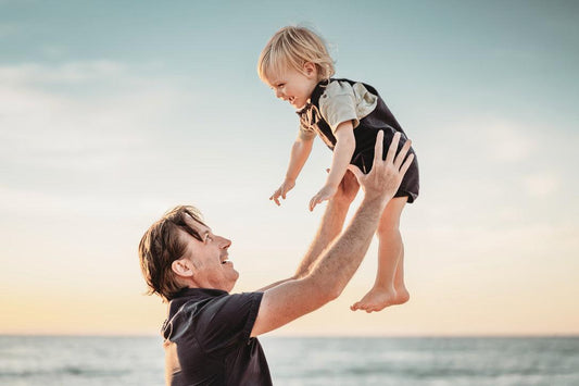Man throws toddler into the air at the beach