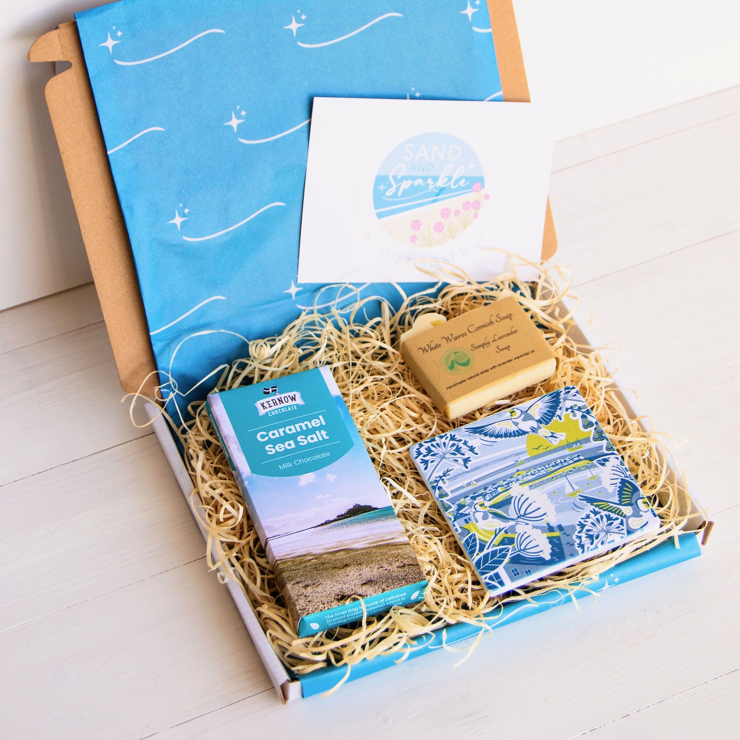 cornish coastal letterbox gift set with illustrated coaster, artisan chocolate and handcrafted soap