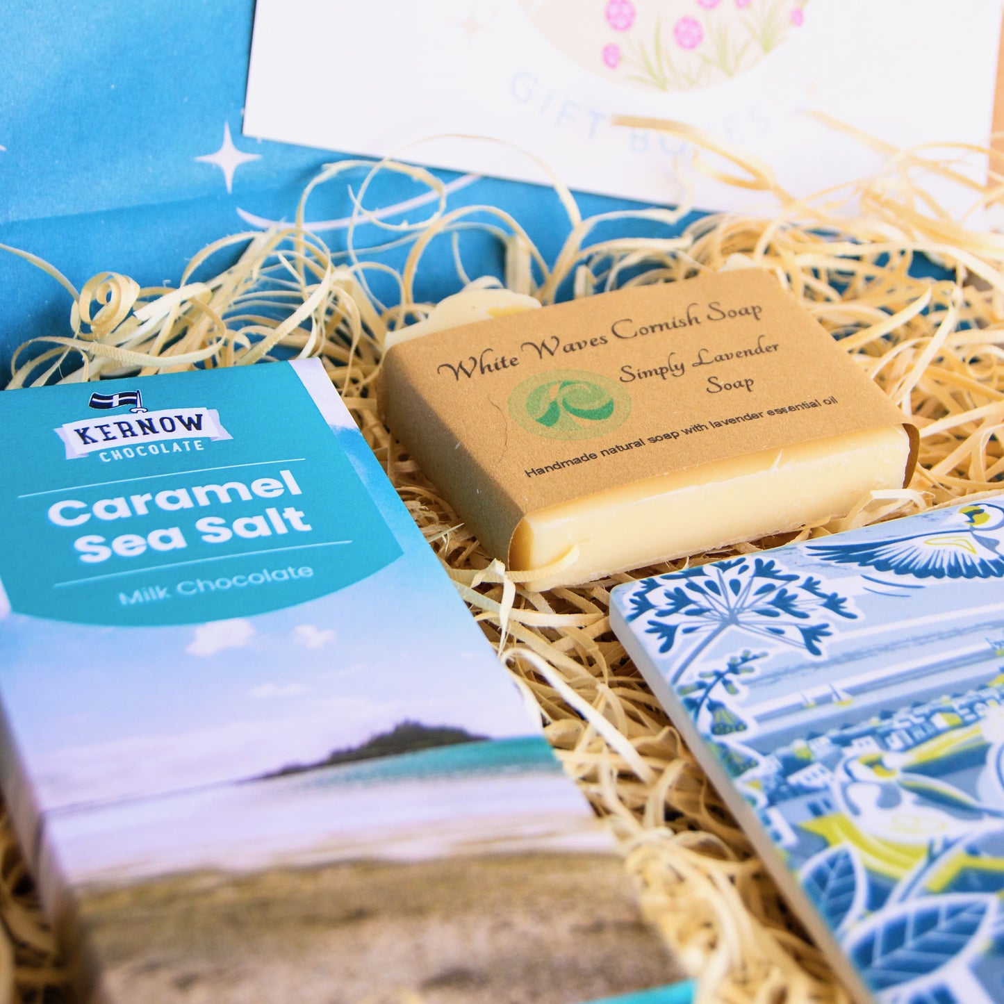 cornish coastal letterbox gift set with illustrated coaster, artisan chocolate and handcrafted soap