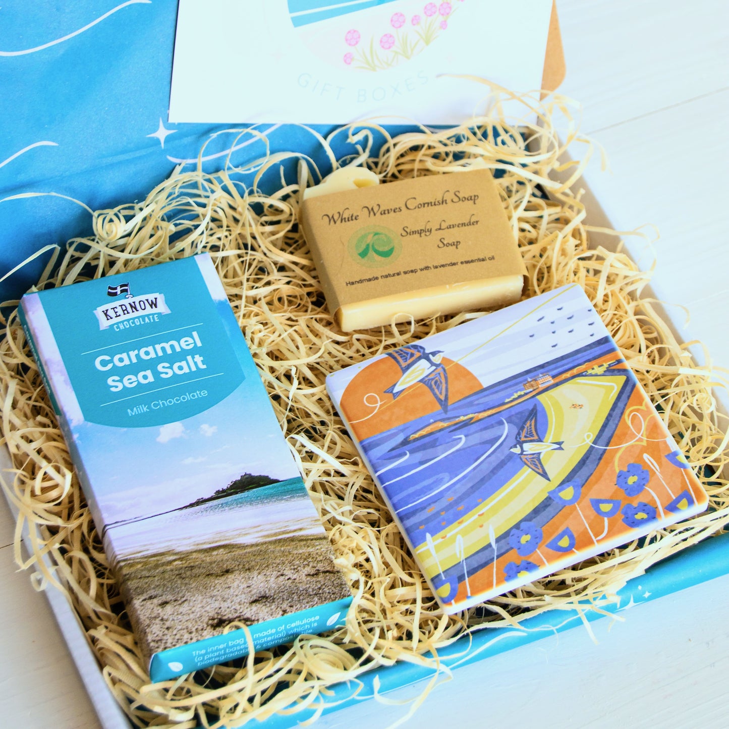 cornish coastal letterbox gift set with illustrated coaster, artisan chocolate and handcrafted soap