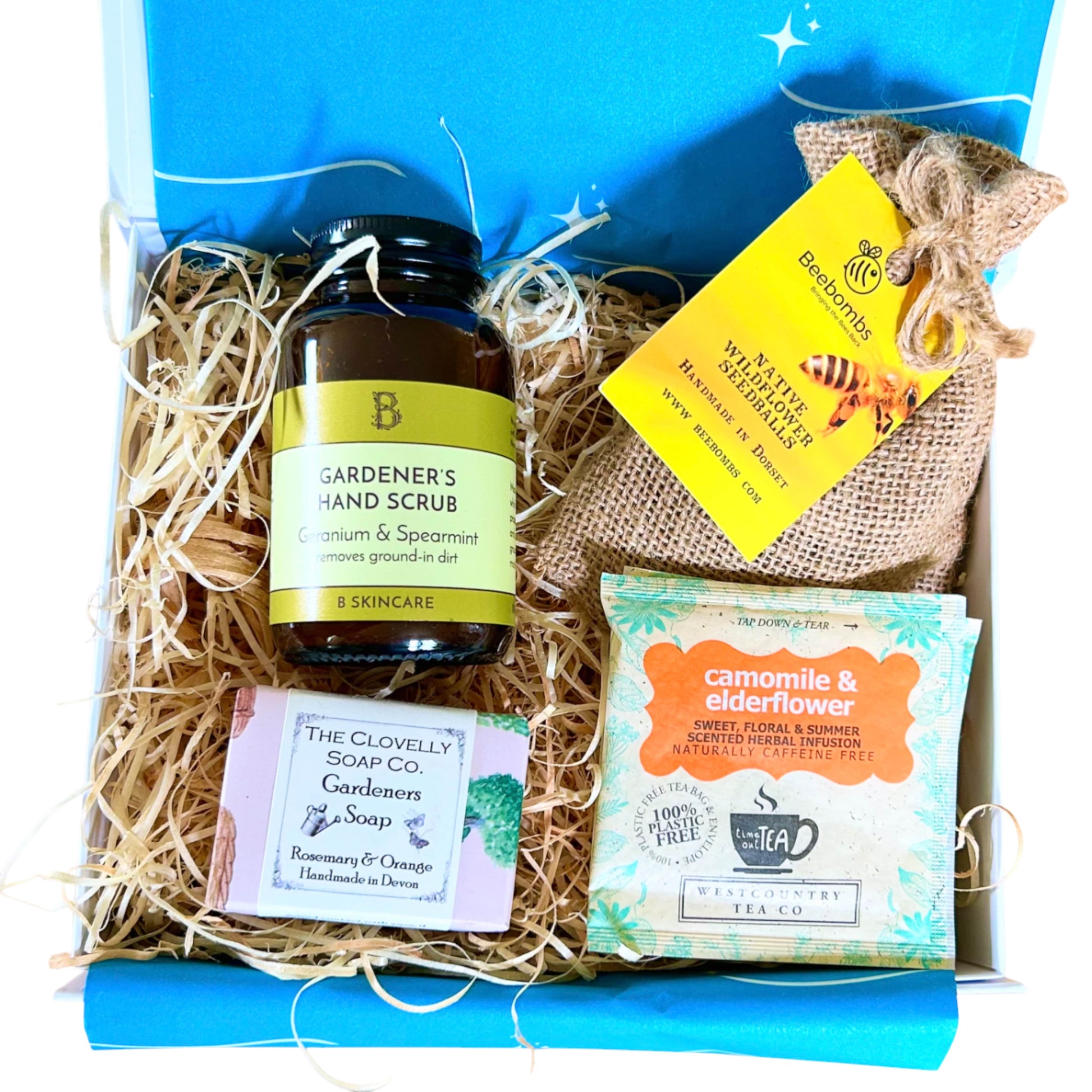 Gardener's gift  hamper with 'Gardener's Hand Scrub', 'Gardeners Soap', and 'Camomile & Elderflower' tea in a box as well as Beebombs wild flower seeds to create a wild flower meadow.